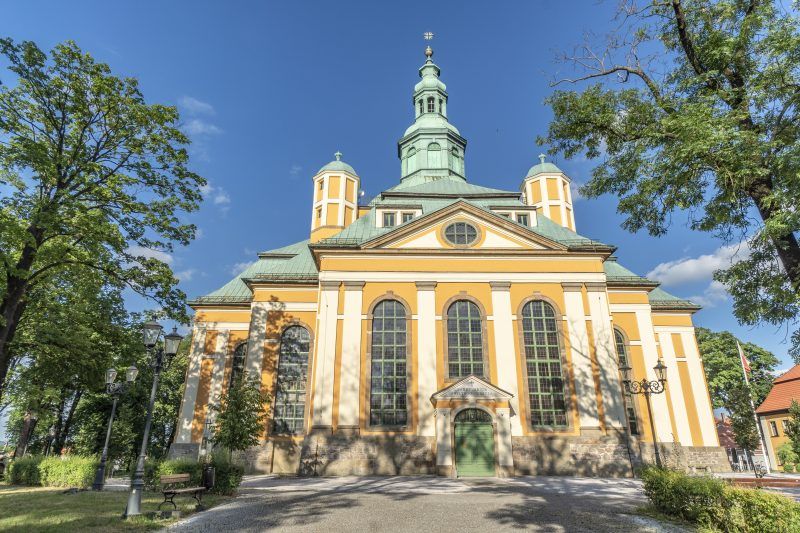 Kościół w stylu barokowym na planie krzyża greckiego z płaską kopułą w centrum otoczoną czterema wieżyczkam.