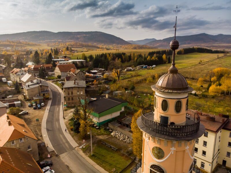 Widok na budynki, kościół, wzgórza z lotu ptaka.