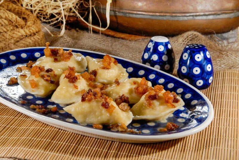 Talerz wypełniony pierogami na niebieskiej ceramice bolesławieckiej