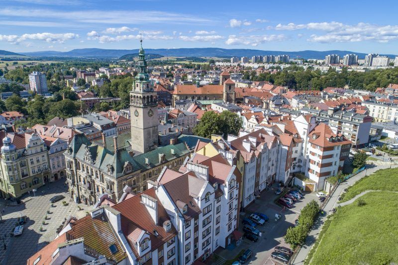 Widok z lotu ptaka na miasto Kłodzko oraz przyroda w tle.