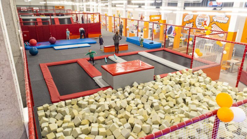 Park trampolin z kilkunastoma dużymi trampolinami, basenem wypełnionym gąbkami.