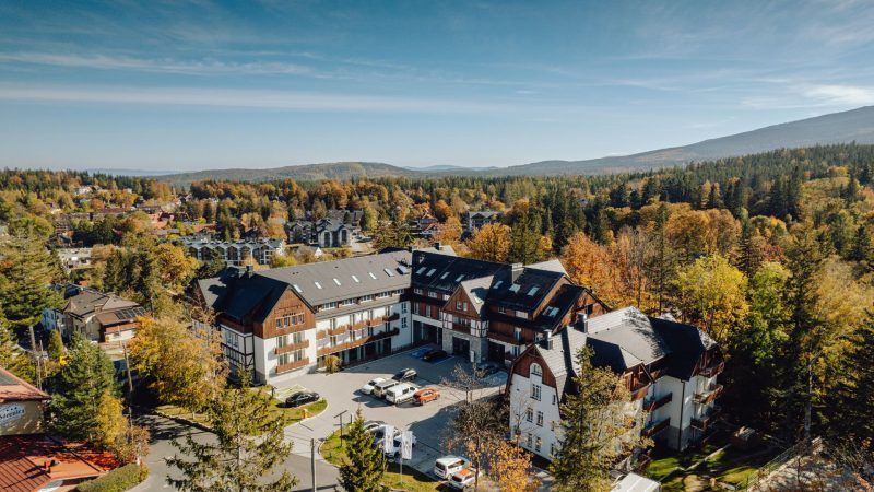 Zdjęcie z lotu ptaka z widokiem na budynek hotelu w Szklarskiej Porębie w otoczeniu jesiennej przyrody