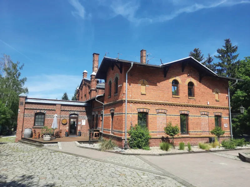 Widok na zabytkowy, niewielki, nieotynkowany budynek gazowni