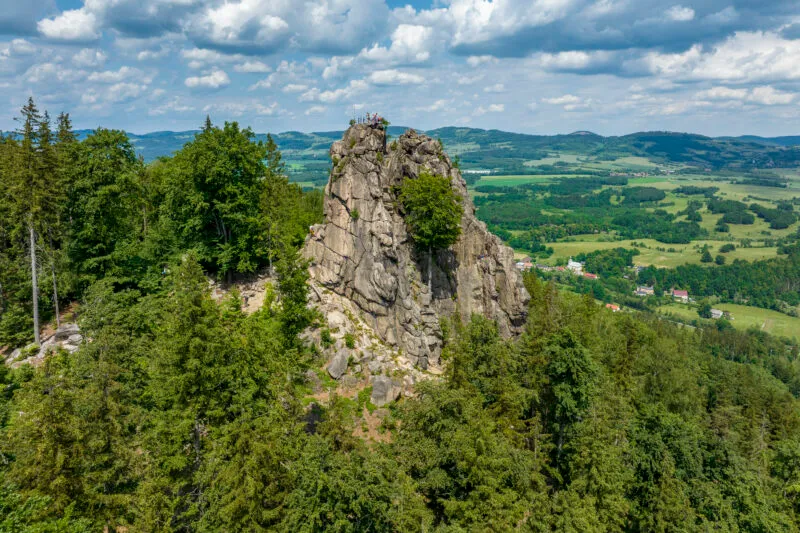 Skaliste Sokoliki wyrastają ponad zielonym lasem w Rudawach Janowickich, otwierając rozległy widok na mozaikę pól, miejscowości i pasma wzgórz.