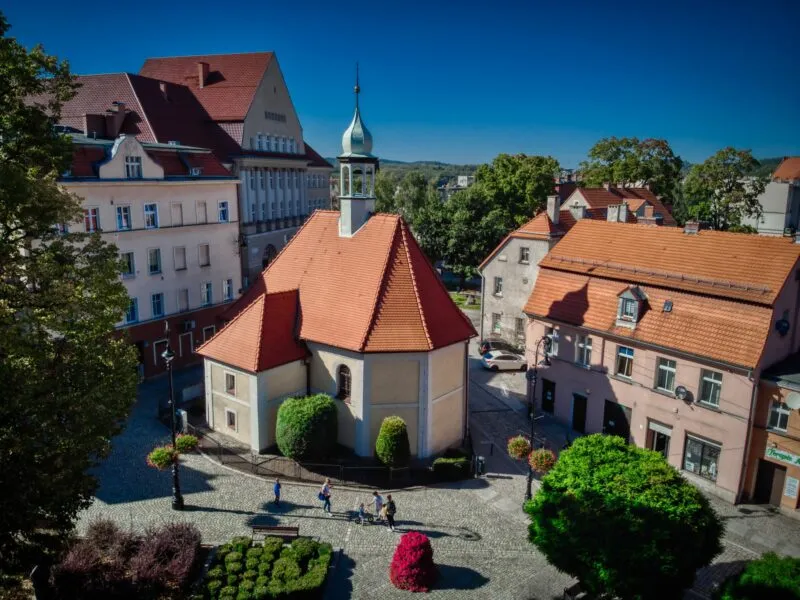 Widok z wysokości na zabudowę w miasta Wałbrzych z małym kościołem widocznym w centrum kadru