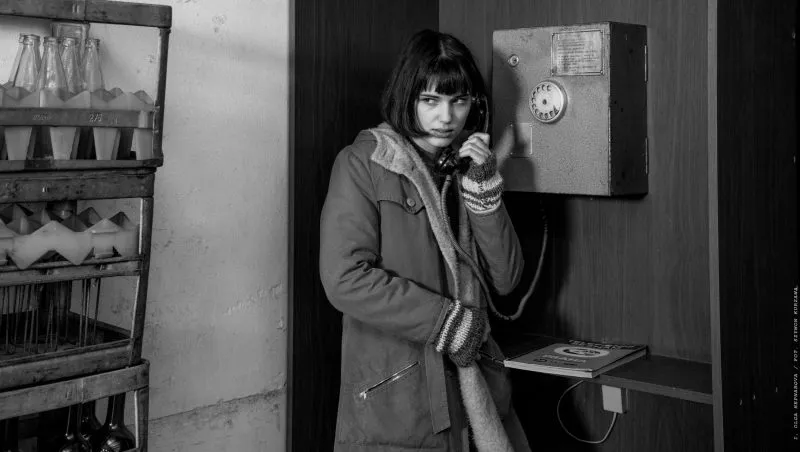 Czarno-białe zdjęcie przedstawiające kobietę rozmawiającą przez telefon.