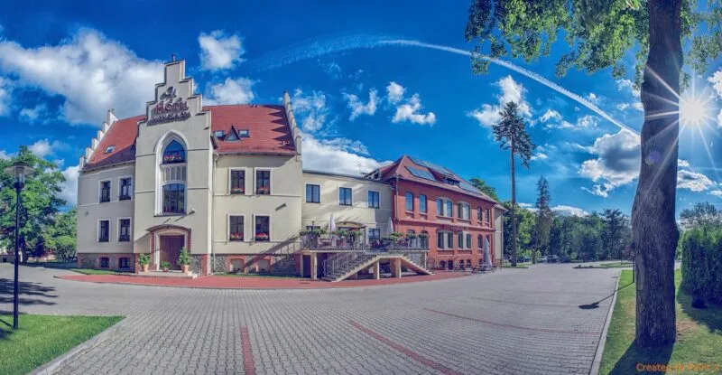 Budynek hotelu w kolorach jasnych i czerwonych na tle jasnego nieba w dzień