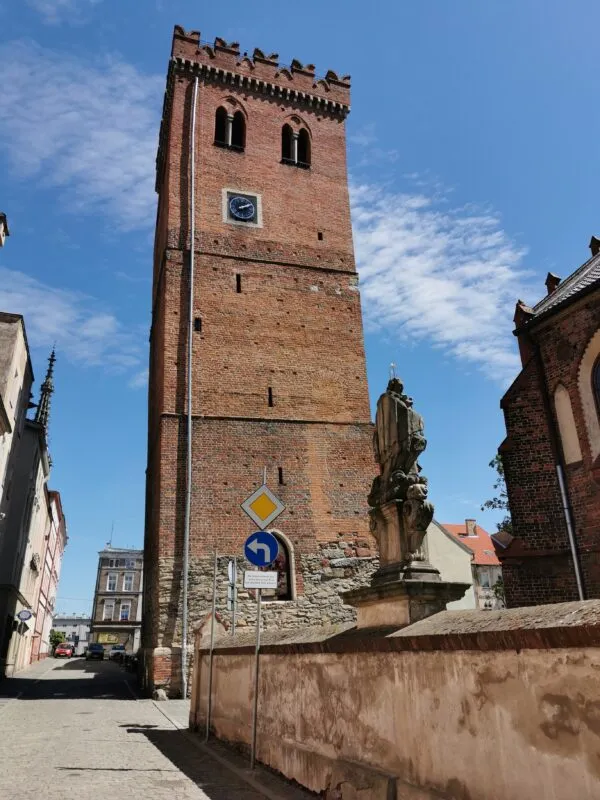 Krzywa Wieża z czerwonej cegły na tle jasnego nieba