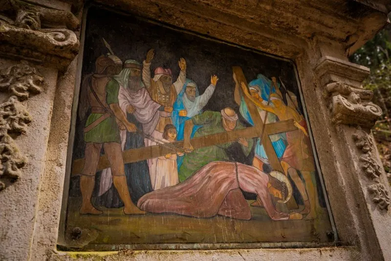 Widok na górską drogę Krzyżową w Bardzie z turystą maszerującym w oddali