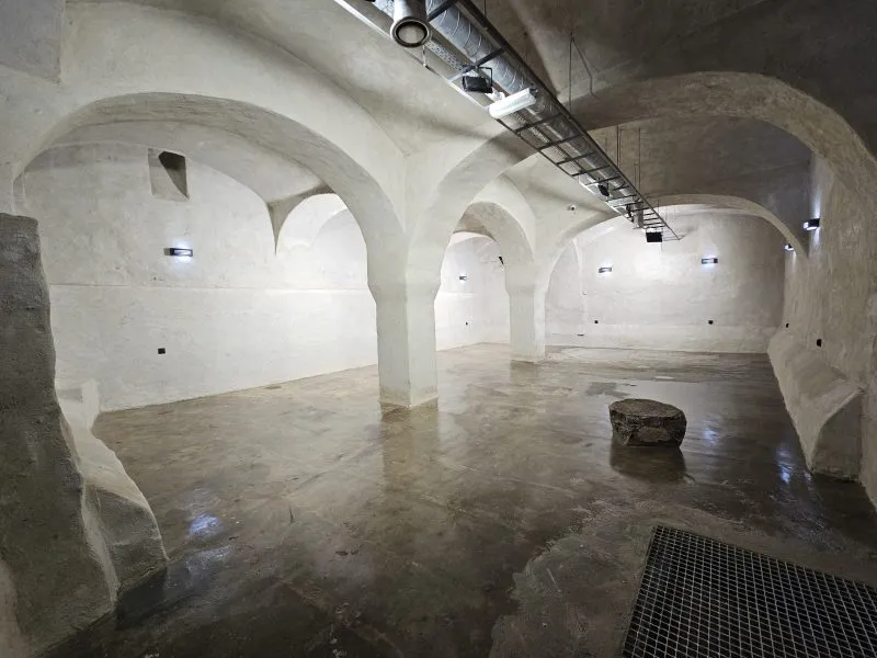 The bright underground hall of the former brewery in Bystrzyca Kłodzka has stone vaults supported by massive pillars and a round well in the floor.