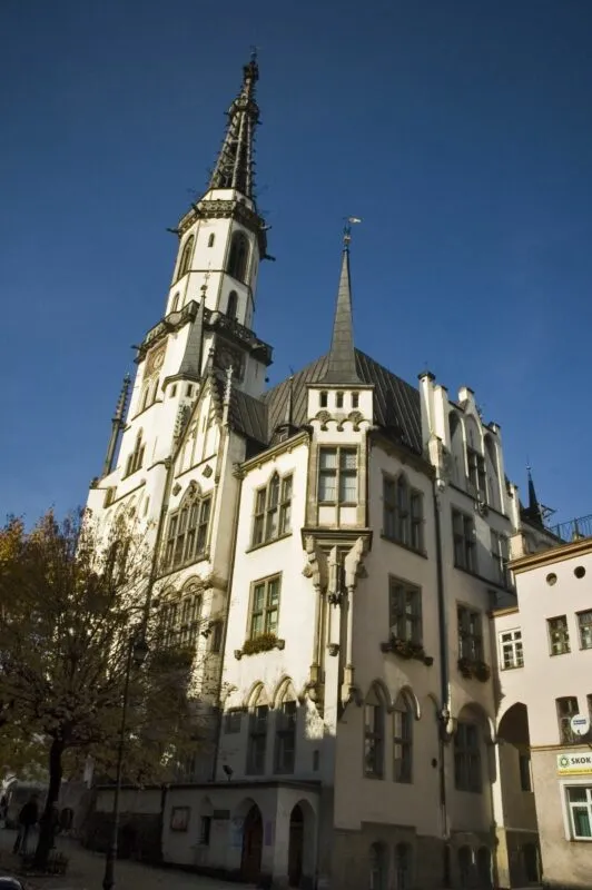 Widok na ratusz z jasną elewacją i ciemnym obramowaniem wokół okien.