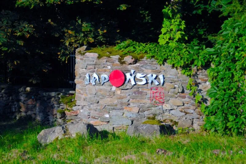 Napis "Japoński" przymocowany do skalnego muru w otoczeniu zieleni
