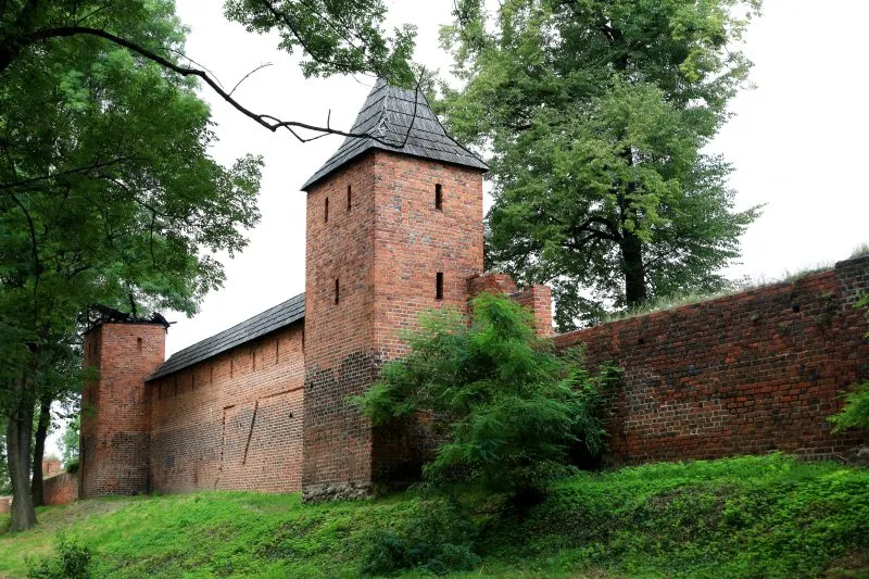 Odrestaurowany fragment murów miejskich w Środzie Śląskiej z widoczną basztą
